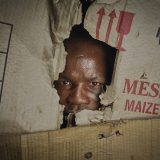 Tjilanbi Mwaongana, 30, looks out through his cardboard house. Most of the inhabitants of Etunda Refugee Camp build their shelters with pieces of cardboard boxes and leftover blankets.