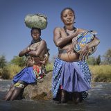 Kahakojo (left) and Rosa (right) at Kunene river which they crossed when they migrated from Angola due to the drought causing hunger in their villages.
