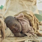 A child wakes up after sleeping in the open at Otuzemba, an area in Opuwo where migrants coming from Angola have settled.