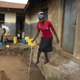 Slivia tries to negotiate steps outside her home in Uganda.