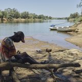 The Kunene River that splits Angola and Namibia. Police boats potrol the river to prevent migrants from crossing into Namibia in the hope fertile land and a better life. They explain that many are lost crossing the river, taken by the numerous crocodiles.