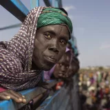 Nyakang Pawo Nhial, 40 years. At Joda ( boder point of Sudan and South Sudan). She looks out of a truck that will be transporting her and many other families that have fled the sudan war to the transit center in Renk, where they will temporarily reside as they wait for help.